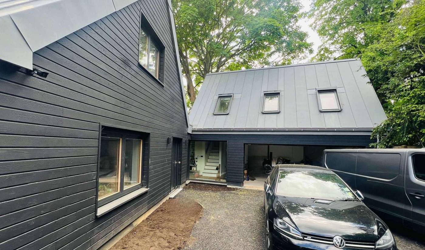 Charcoal-clad home and garage studio with standing seam roof