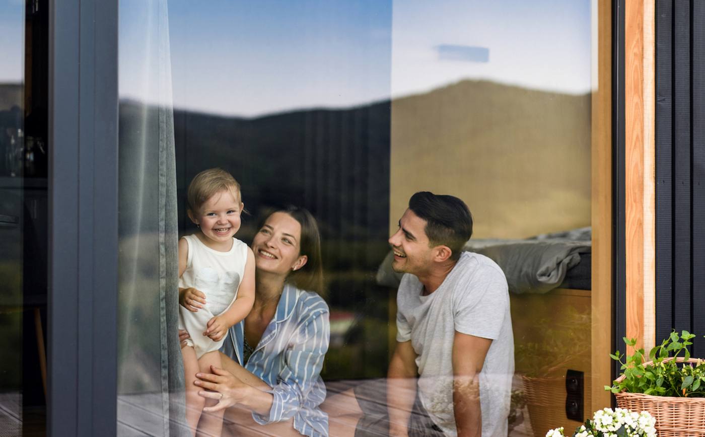 Family relaxing by a large window in a warm, light-filled home