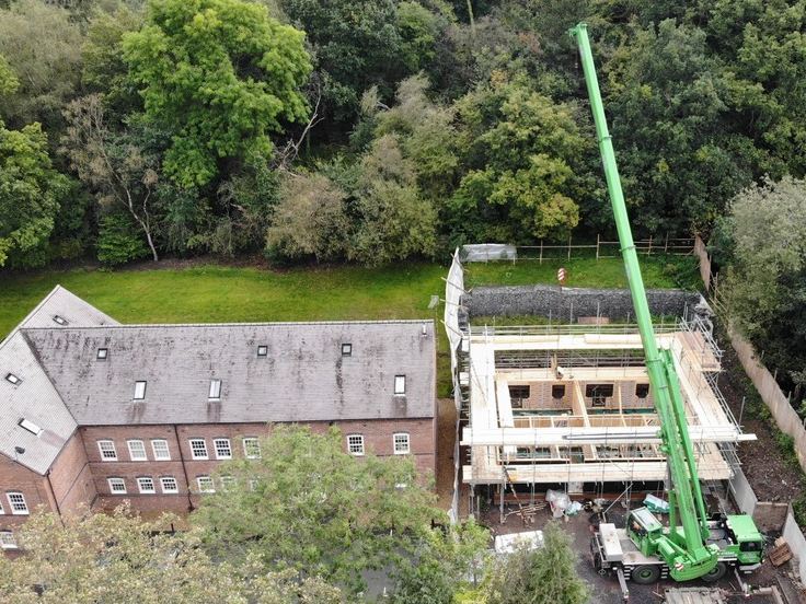 Crane lifting manufactured panels into place on a residential site